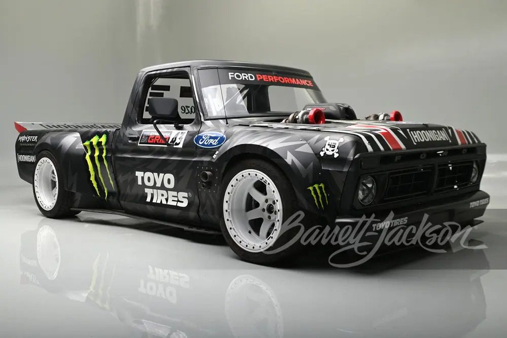 A custom black Ford F-150, known as the Hoonitruck, boasts 917HP with Ford branding and Toyo Tires logo. It features wide tires, a low body stance, and eye-catching decals, including Monster Energy logos.