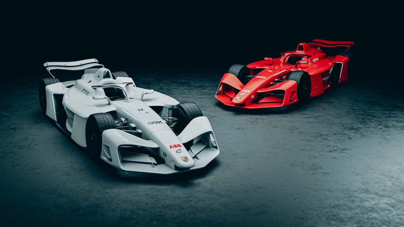 Two Porsche Formula E factory cars, one white and one red, are parked on a dark, textured surface in a dimly lit environment.