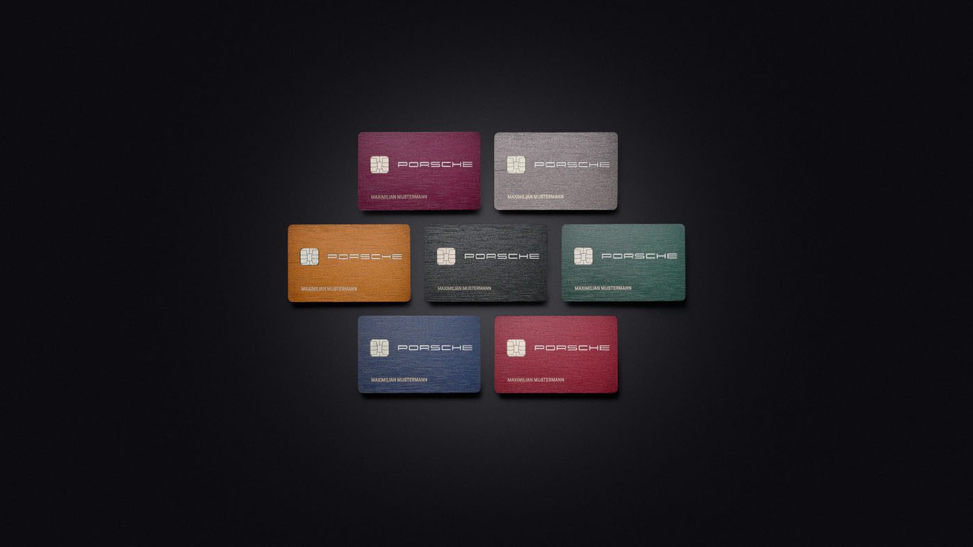 Seven Porsche credit cards, each displaying the Porsche logo, are arranged on a black background in vibrant shades of yellow, red, green, blue, and gray.
