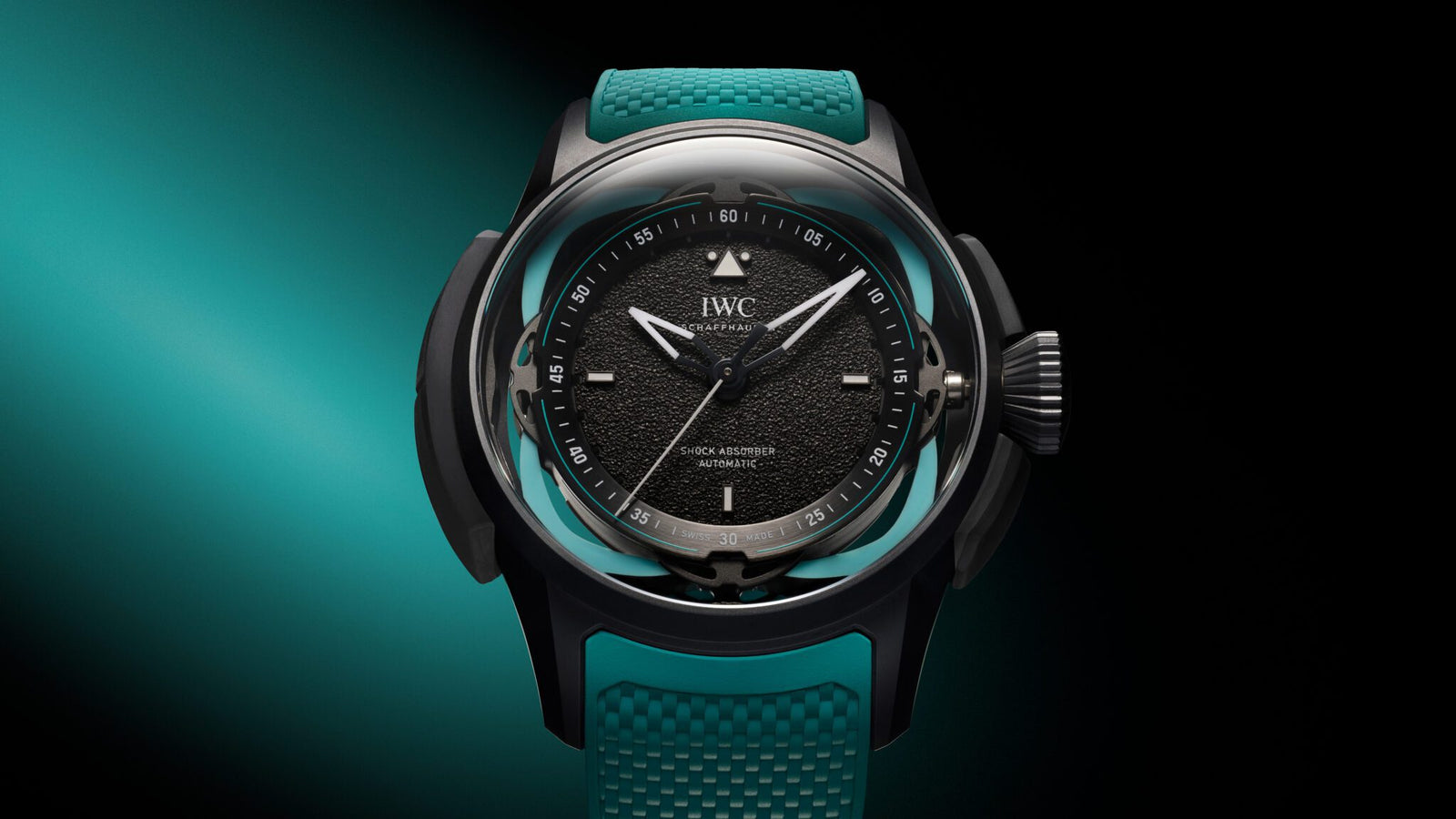 A black watch with a textured dial, luminescent hands, and teal accents is elegantly showcased against a gradient aqua and black background, inspired by the Toto Wolff Edition Big Pilot’s Watch.