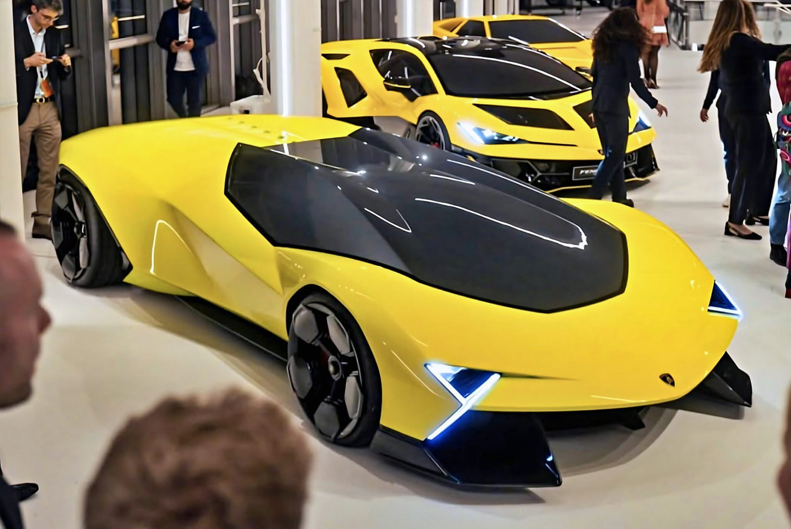 Two yellow Lamborghini concept cars, including the striking Lamborghini Manifesto Concept, are displayed indoors with people standing and walking around them at the Centro Stile anniversary event.