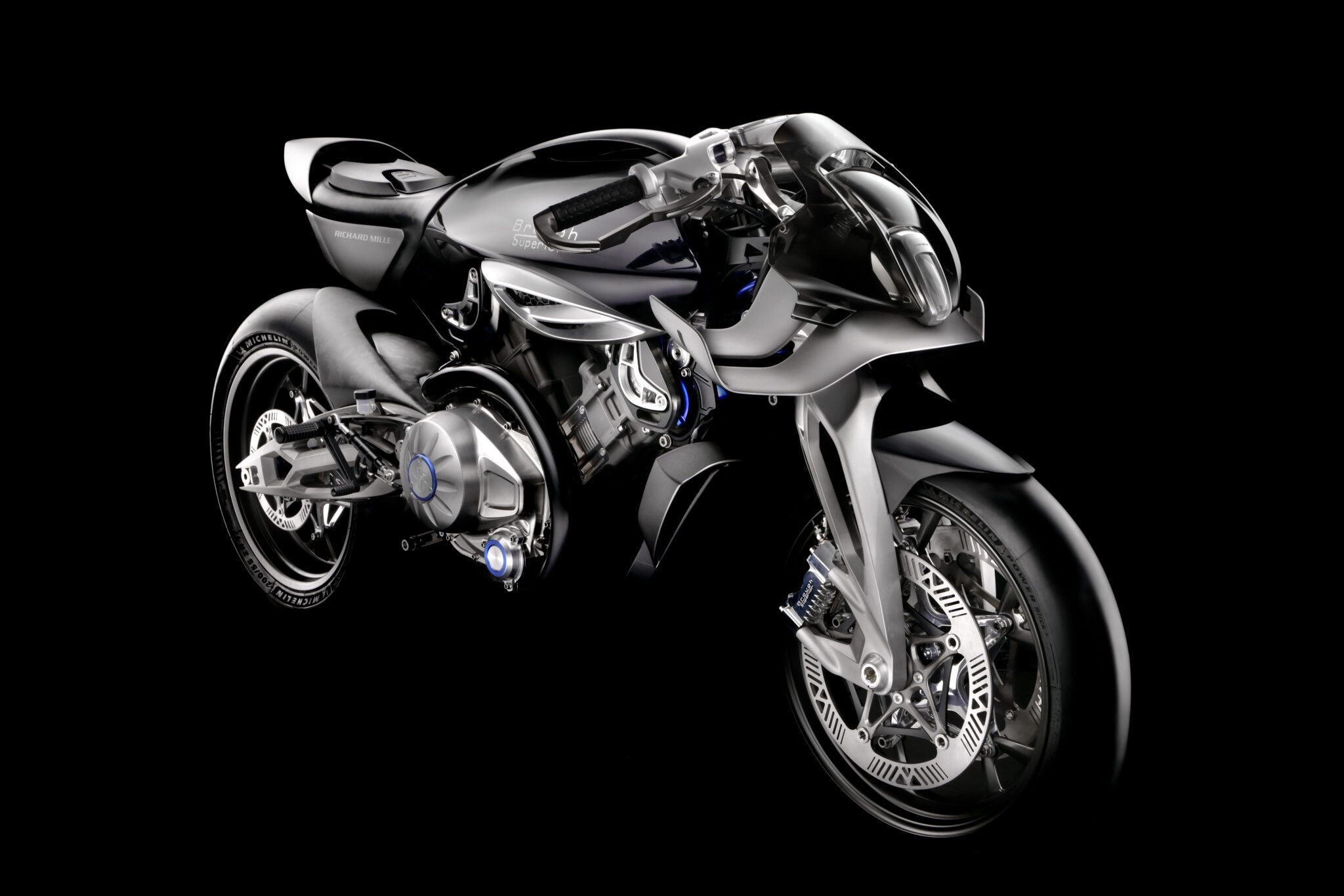 Futuristic black and silver RMB01 Track Motorcycle concept inspired by Brough Superior and Richard Mille, featuring a sleek aerodynamic design and exposed mechanical parts, set against a solid black background.