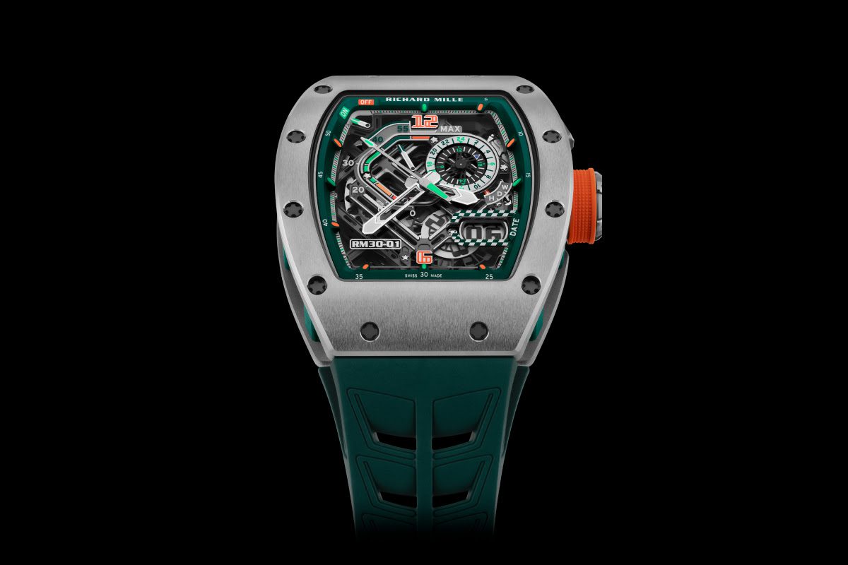 A silver Richard Mille RM 30-01 LMC watch with a skeleton dial, orange crown, and teal strap, displaying intricate mechanics and chronograph features against a black background—a true Le Mans Classic edition.