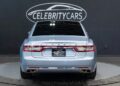 Rear view of a rare, light blue Lincoln Continental sedan in a showroom, featuring the distinctive "Celebrity Cars Las Vegas" license plate frame.