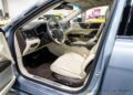 The opulent interior of this Lincoln Continental Coach Door Edition showcases beige leather seats, a sleek steering wheel, and an elegant dashboard with the driver's door invitingly open. For sale now, this car epitomizes luxury with every refined detail.