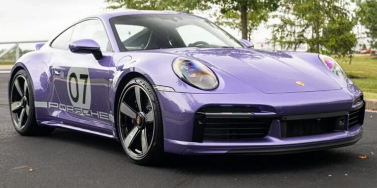 A metallic purple Porsche 911 Sport Classic, marked with the number 07 on its side, sits parked on a paved surface with trees in the background.