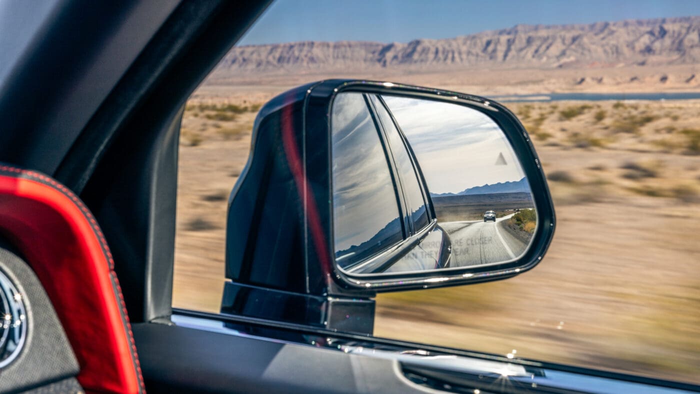 An image of a car mirror as it drives on the highway.