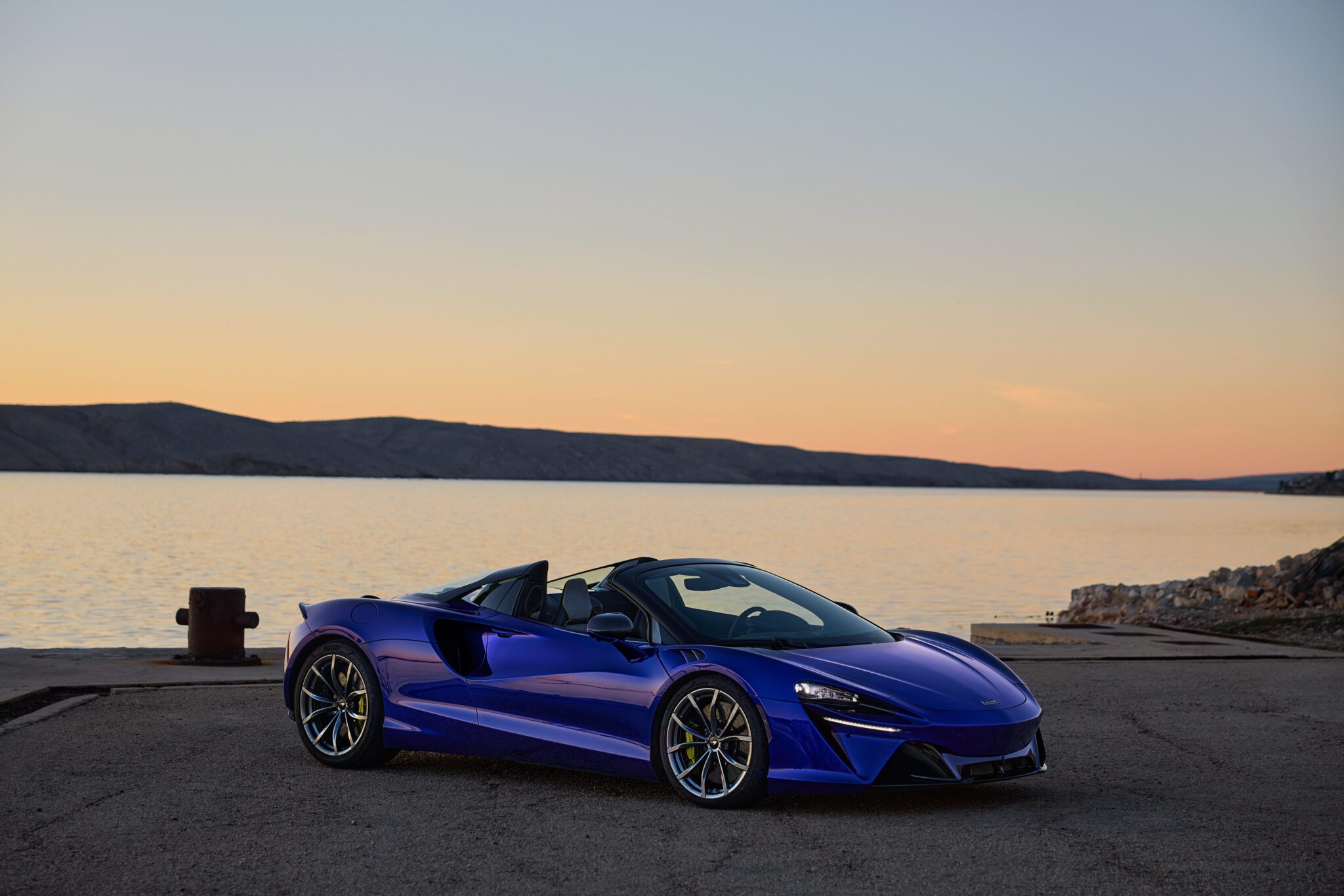 An image of a blue supercar parked outdoors.