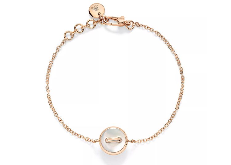 Gold chain bracelet with a circular pendant featuring a short bar in the center, making it a perfect Valentines Day Gift. The clasp is adjustable with a small engraved tag, ensuring it fits just right. As featured in duPont REGISTRY, this piece shines with elegance and charm.