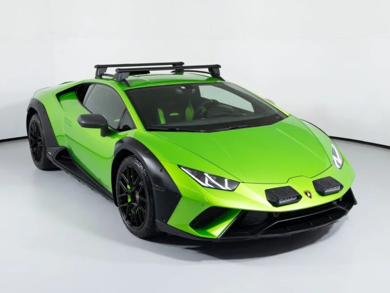 A green sports car, perfect for a St. Patrick's Day adventure, sits parked with its roof rack and black accents in a plain white space.