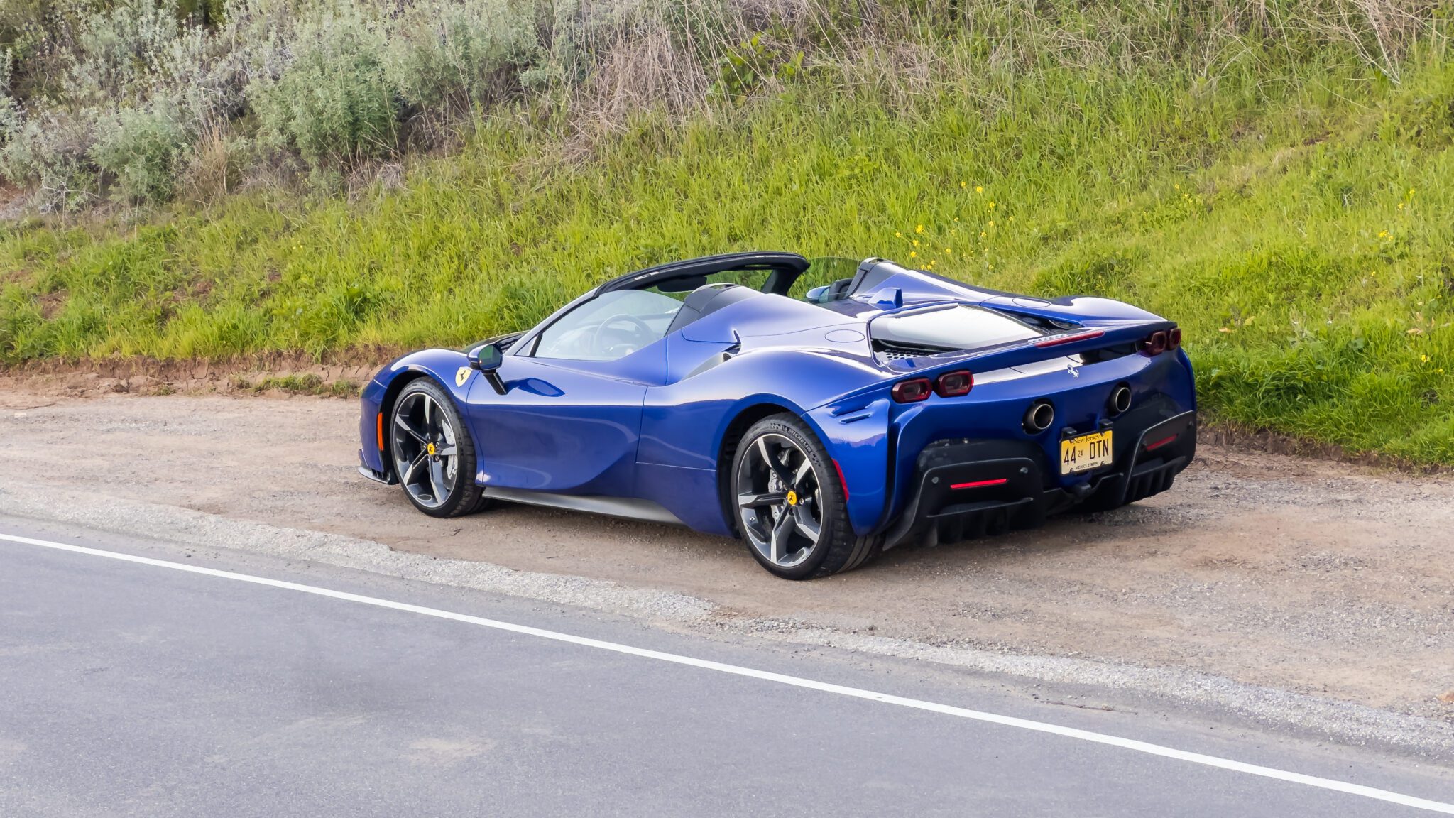 An image of a blue Ferrari SF90 parked outdoors.