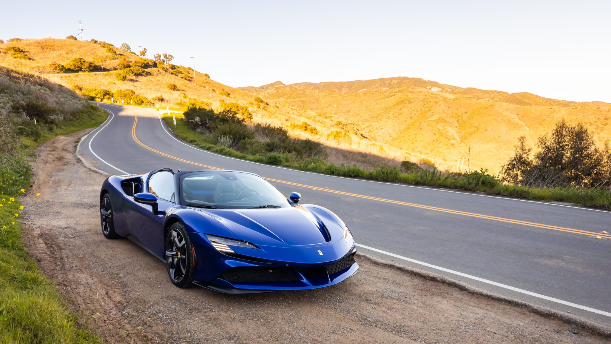 An image of a blue Ferrari SF90 Spider parked outdoors.