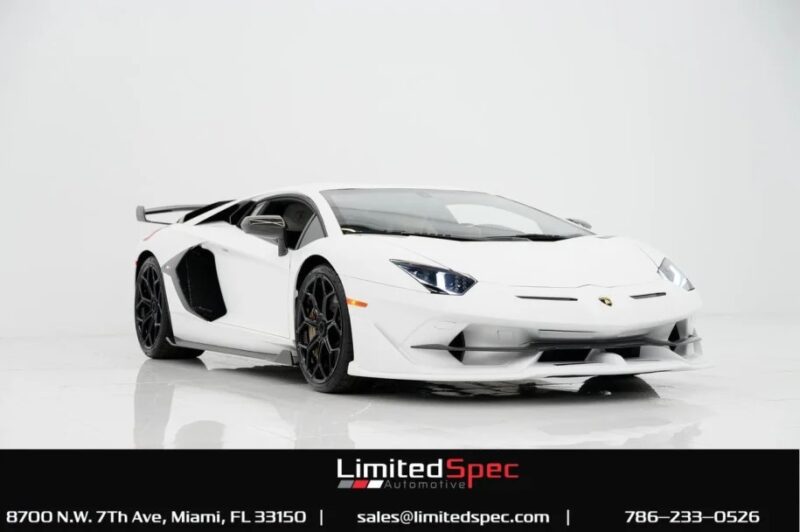 A sleek white Lamborghini Aventador SVJ graces the showroom floor, showcasing its stunning design and performance. For those looking to buy a Lamborghini, contact LimitedSpec Automotive for details at the bottom.