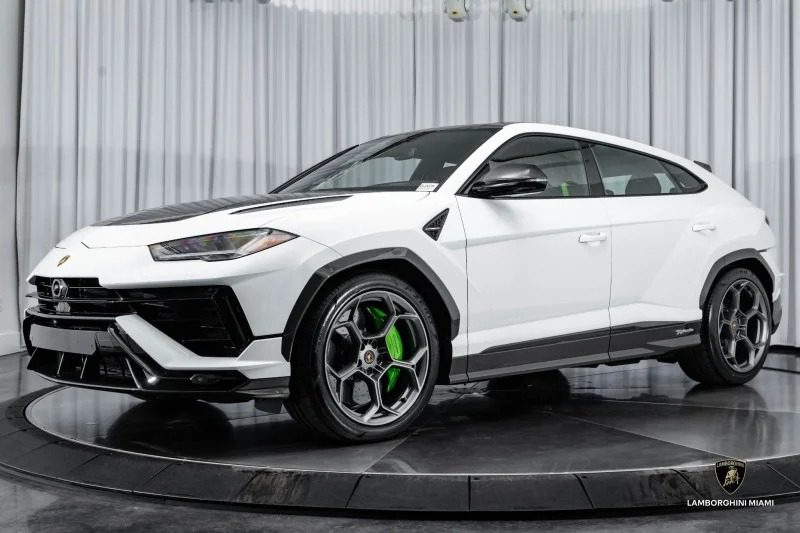 A white Lamborghini Urus, epitomizing luxury and performance, is on display in a showroom with sleek black floors and curtains, showcasing the pinnacle of super SUVs.