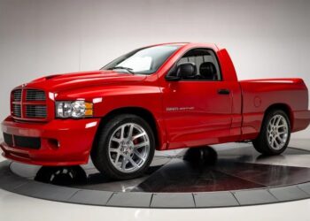 A red Dodge Ram SRT-10 truck, an example of bold design, is parked indoors, showcasing its chrome wheels and distinctive grille.