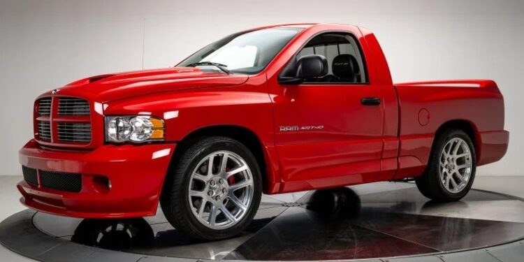 A red Dodge Ram SRT-10 truck, an example of bold design, is parked indoors, showcasing its chrome wheels and distinctive grille.