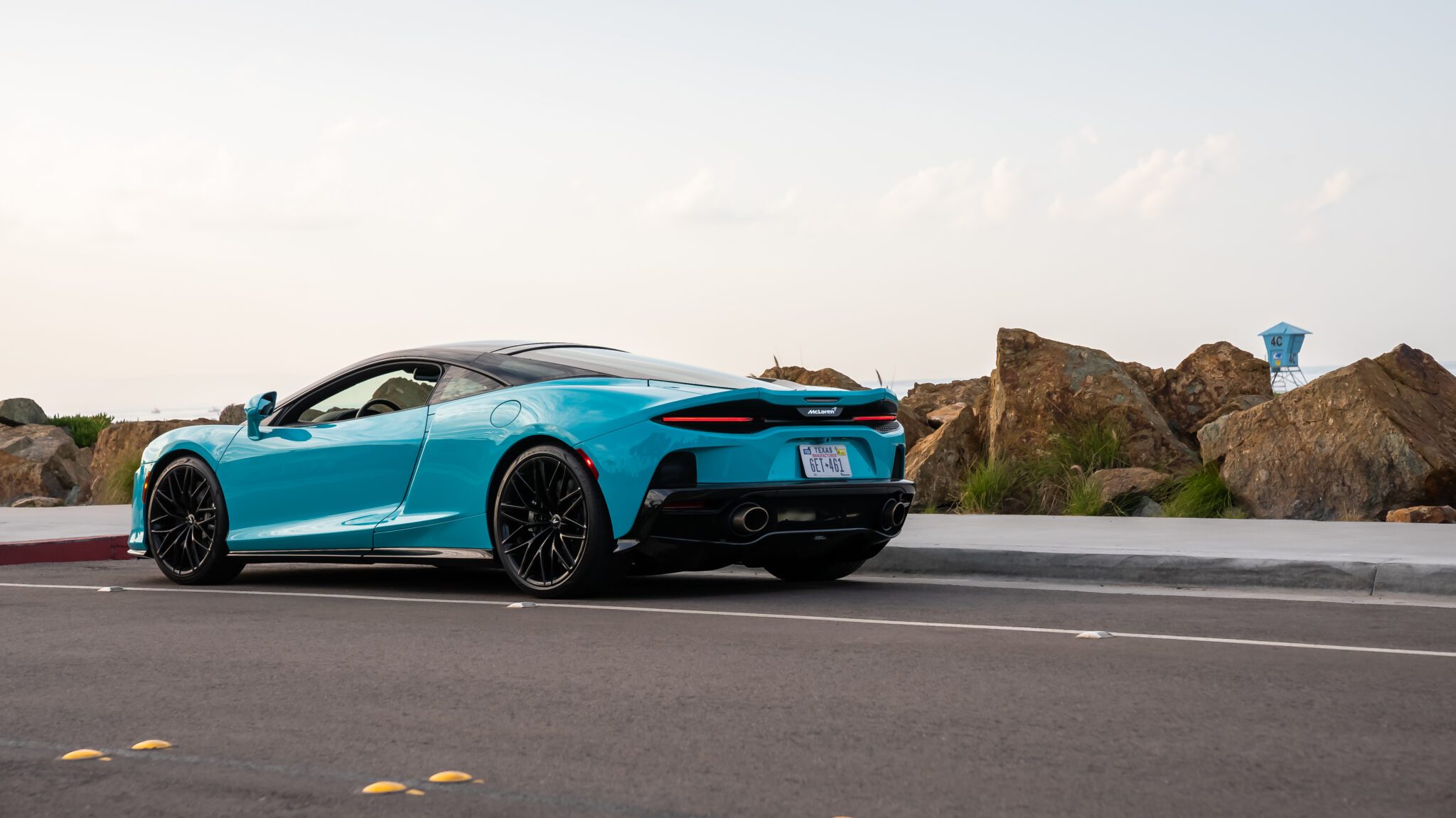 A 2023 McLaren GT parked across from a beach.