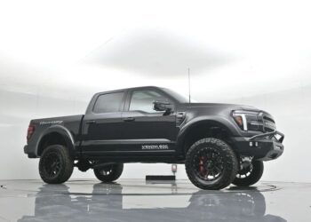 A black Hennessey VelociRaptor 600 pickup truck, blending luxury truck style with off-road capability, is parked in a white studio showcasing its lifted suspension and rugged tires.