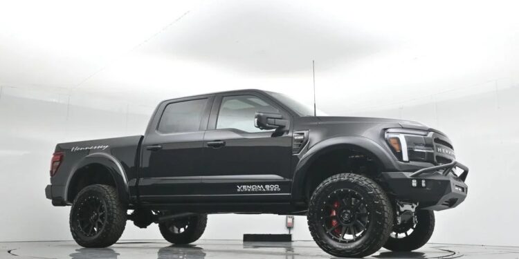 A black Hennessey VelociRaptor 600 pickup truck, blending luxury truck style with off-road capability, is parked in a white studio showcasing its lifted suspension and rugged tires.