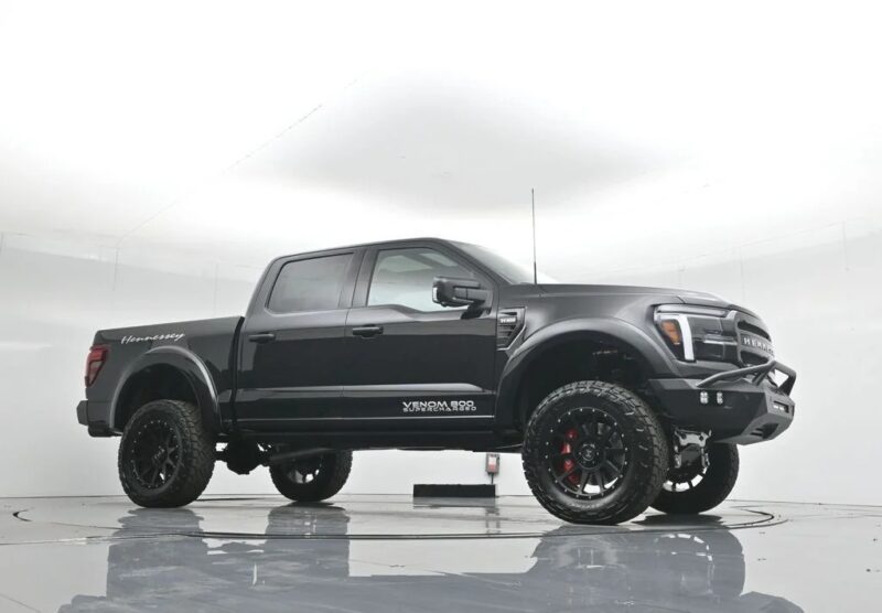 A black Hennessey VelociRaptor 600 pickup truck, blending luxury truck style with off-road capability, is parked in a white studio showcasing its lifted suspension and rugged tires.