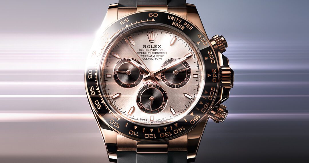 A Rolex Oyster Perpetual Cosmograph Daytona, one of the most iconic luxury chronographs, featuring a rose gold case, black bezel, and black rubber strap set against a blurred gradient background that evokes automotive elegance.