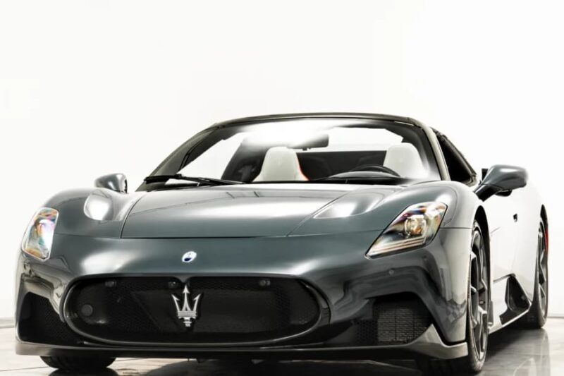 Front view of a dark gray Maserati sports car with the brand's iconic trident logo on the grille, showcasing Italian luxury against a plain white background. This stunning vehicle is now available for sale.