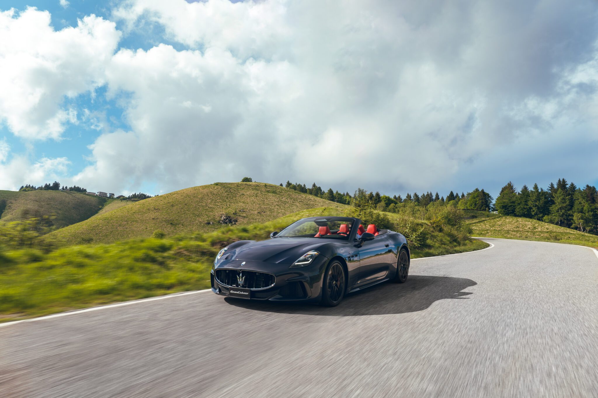 An image of a car driving on an empty road.