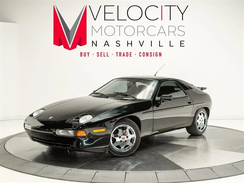 Sebuah mobil sport Porsche hitam, salah satu mobil klasik tanpa tanda jasa, tampil memukau di ruang pamer di bawah logo Velocity Motorcars Nashville, mengundang para penggemar untuk berinvestasi dalam daya tariknya yang tak lekang oleh waktu.