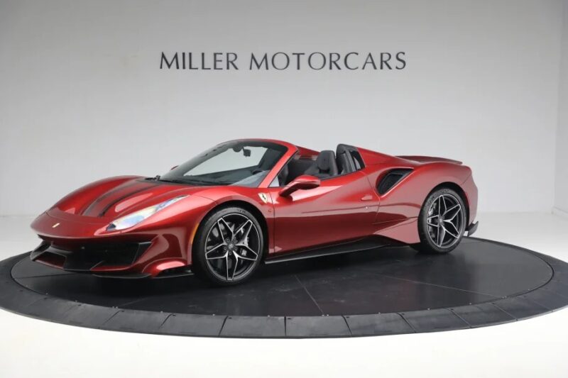 A red convertible sports car, a Ferrari 488 Pista, is displayed in the showroom with "Miller Motorcars" on the wall. This track-ready marvel is now for sale.