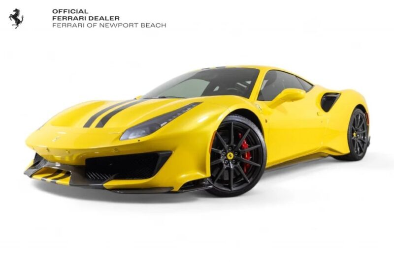 A dazzling yellow Ferrari 488 Pistas with sleek black stripes is showcased in the showroom, track-ready and available for sale.