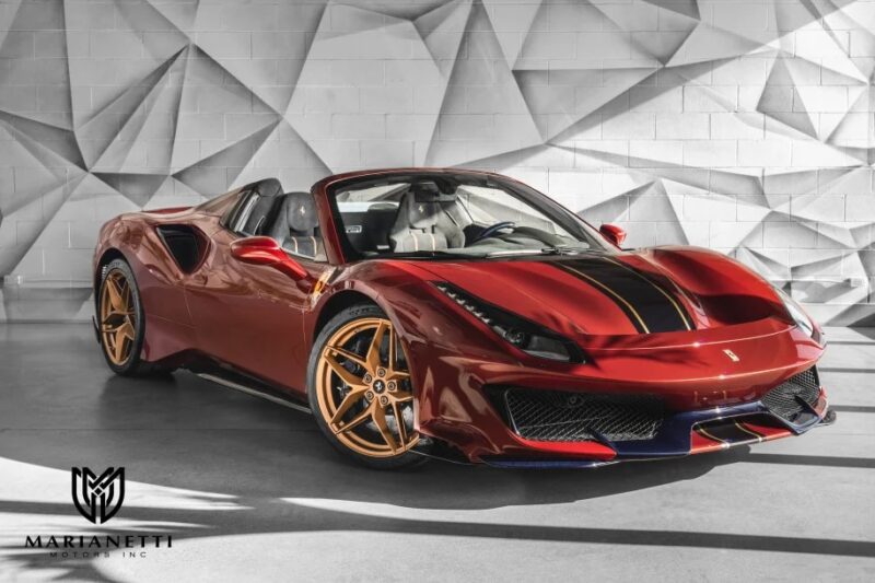 A stunning Ferrari 488 Pista with gold wheels is parked indoors against a geometric patterned wall. This track-ready red sports car is now available for sale, offering both style and performance in one dynamic package.