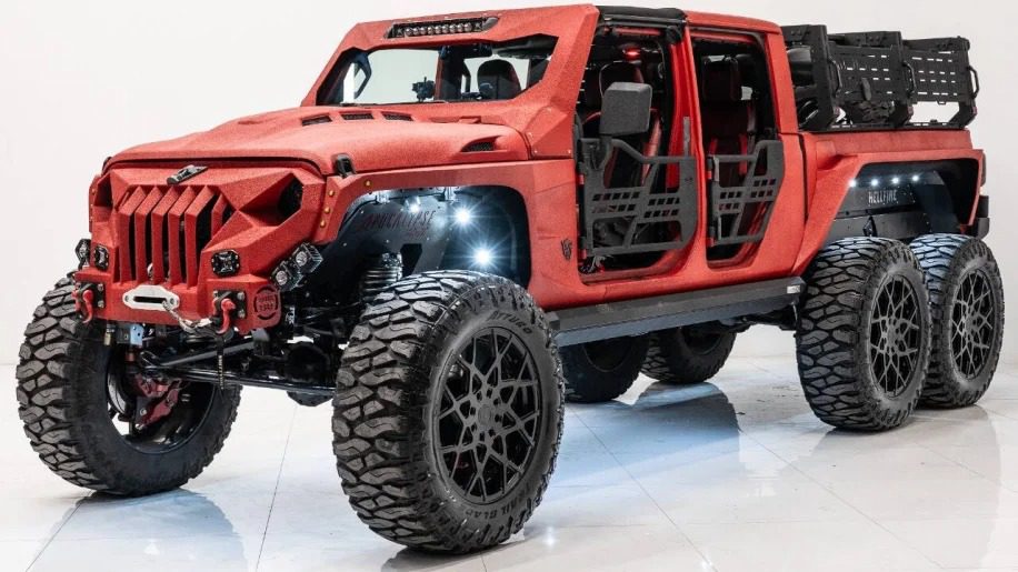 This customized 6x6 truck is a head-turning red off-road vehicle with rugged tires, open doors, and a robust grille design.