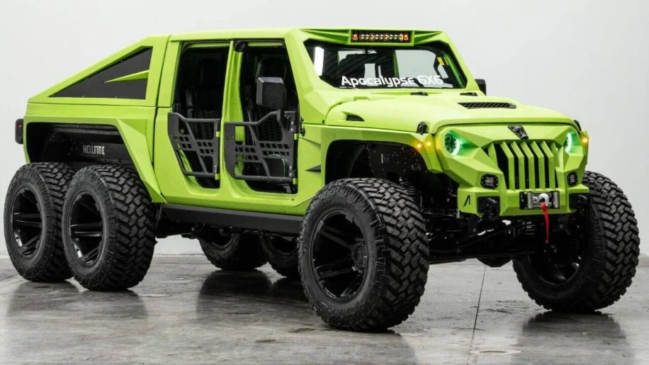 A bright green, heavily modified 6x6 off-road vehicle with an open-frame design is on display indoors, sure to turn heads with its aggressive stance and unparalleled engineering.