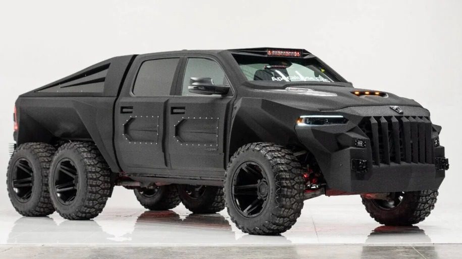 A black, six-wheeled, heavily armored 6x6 truck with an aggressive design is shown against a plain background, sure to turn heads.