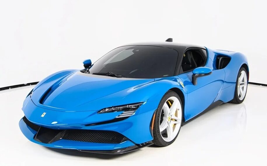 A Ferrari-inspired blue sports car boasts a sleek design and aerodynamic body, featuring contrasting white wheels. It is artfully parked in a pristine studio, with the minimalist white background accentuating its vivid colors for sale.