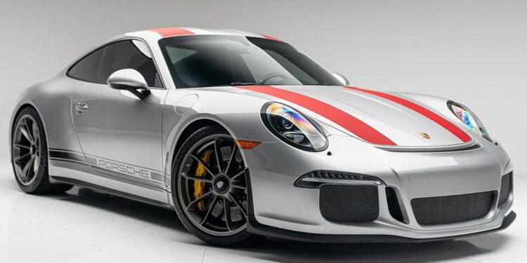 A silver Porsche 911 R sports car with red and gray racing stripes, black wheels, and yellow brake calipers is shown in a studio setting with a white background—an iconic choice for those looking to buy Porsche 911 excellence.