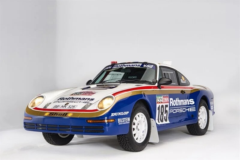 Porsche 959 rally car in Rothmans livery, numbered 185, displayed in a studio setting with a white background—an icon among the Best Air-Cooled Porsches ever built.
