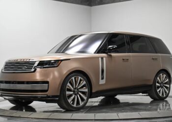 A bronze Range Rover Luxury SUV is displayed in a studio with a white and gray background, viewed from the front left side—a true showcase among the Best Range Rovers.
