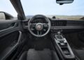 Interior view of a Porsche 911 GT3, showcasing a steering wheel with the iconic logo, a dashboard packed with multiple dials, and a gear shift in the center console—a true testament to its Touring Package.