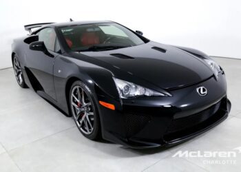Black Lexus sports car with a red interior in a showroom, angled to the left. Branding shows McLaren Charlotte.