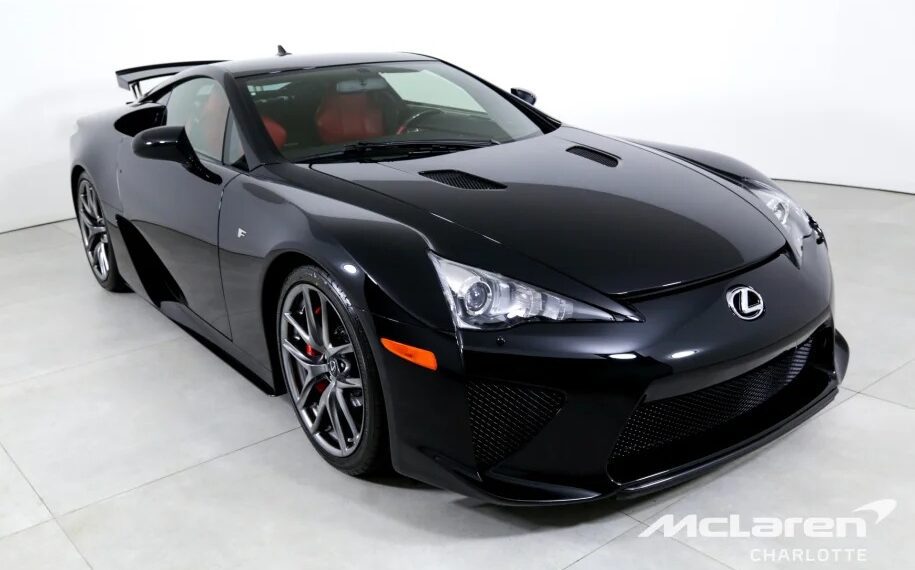 Black Lexus sports car with a red interior in a showroom, angled to the left. Branding shows McLaren Charlotte.