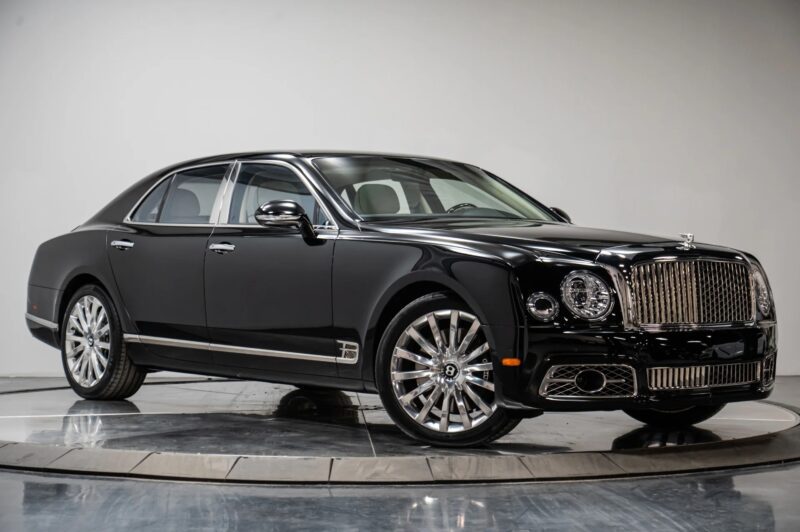 Black luxury Bentley sedan stops on a rotating platform, appearing at a three-quarters-proverb-a wonderful proverb between the best bentleys for sale.