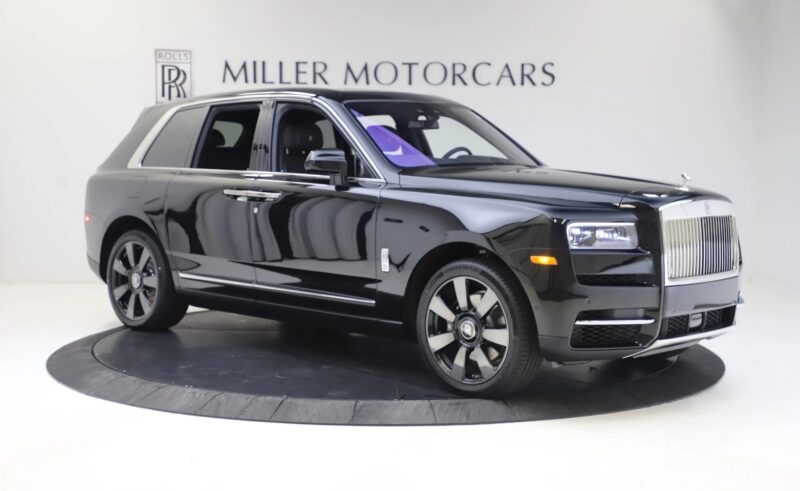 The Rolls-Royce Cullinan, puncak dalam SUV mewah, ditampilkan secara elegan di ruang pamer dengan "Miller Motorcars" signage di atas.