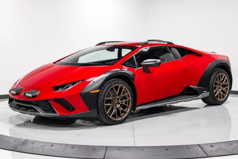 The Lamborghini Huracán Sterrato is a red sports car with a sleek design and black accents, featuring bronze wheels, all elegantly positioned on a white background.