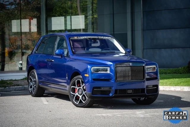 A blue SUV, exuding the pinnacle of luxury vehicle design and high-end detailing, is parked on the street. Showcasing a "CARFAX 1 OWNER" badge, it redefines elegance much like a Rolls-Royce Cullinan in its class.