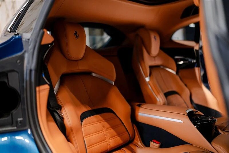 The interior of this Italian Super SUV boasts tan leather seats and a sleek design, with the Lamborghini Urus logo elegantly embossed on the headrests.