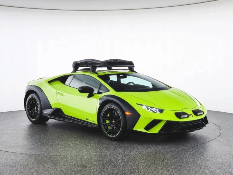 A bright green Lamborghini Huracán Sterrato with a sleek black roof box stands proudly on display in the showroom, offering an irresistible invitation to those looking to make a thrilling purchase.