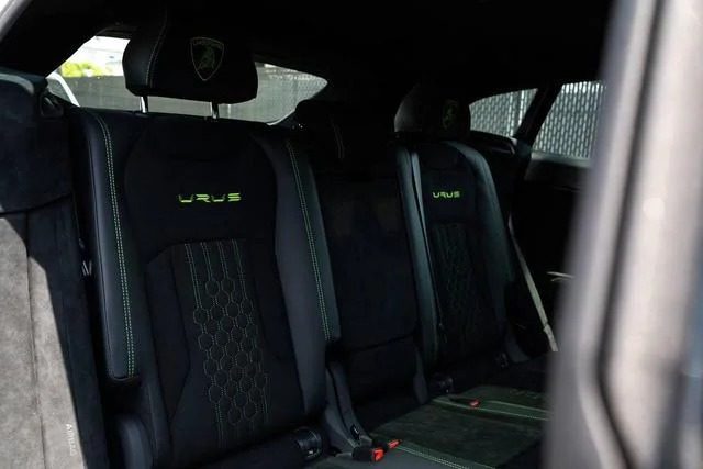 The rear seats of this Italian Super SUV feature the "Urus" logo on the headrests, with green stitching details set against sleek black upholstery, combining luxury and style.