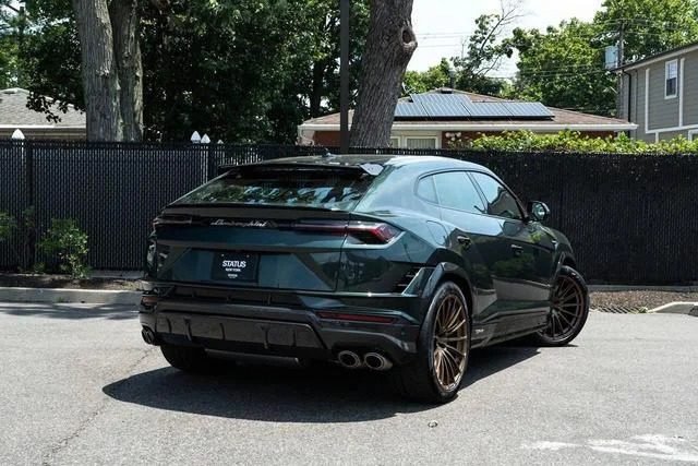 A sleek green Italian Super SUV sits elegantly in a residential area, framed by lush trees and a black fence in the background.