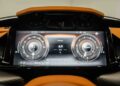 Close-up of a 2025 Aston Martin Vanquish dashboard showcasing a digital speedometer, tachometer, and mileage at 6.9 miles. The sleek display, featuring orange accents, epitomizes the luxury expected from Exclusive Automotive Group.